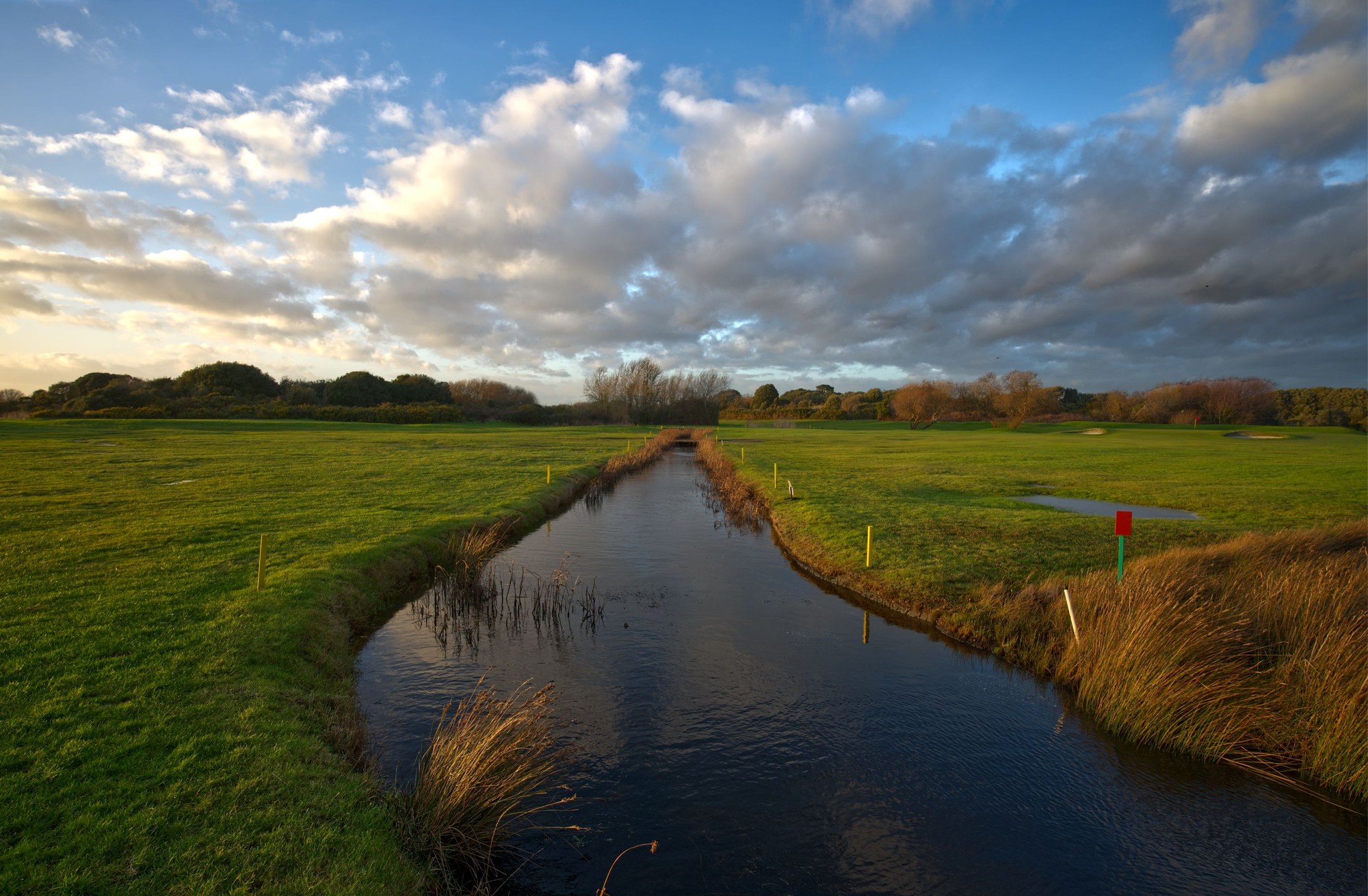 A stream winding through green English countryside